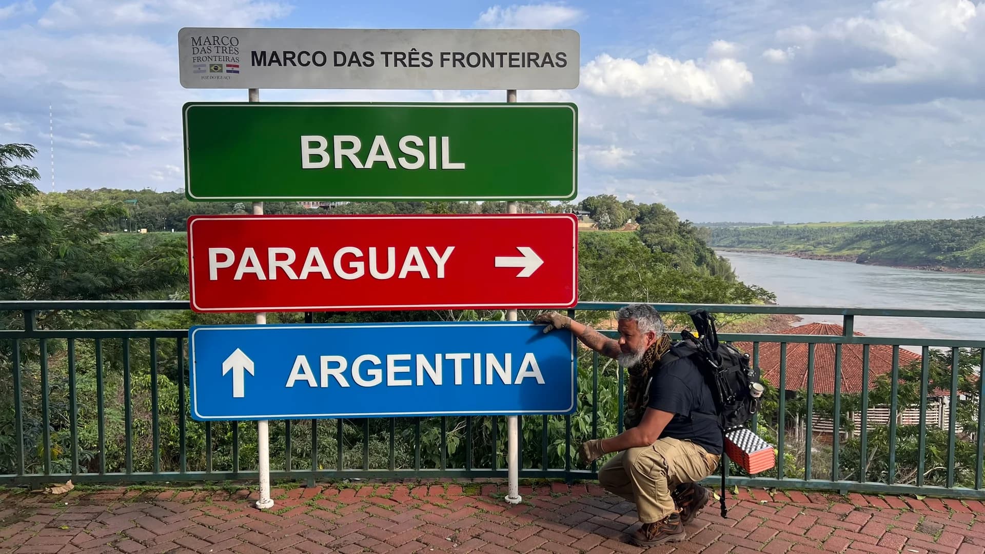 Guia especializado apontando placas do Marco das Três Fronteiras em Foz