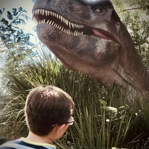 Criança encarando T-Rex no Vale dos Dinossauros Dreamland